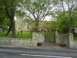 Oblique view of Walls and Gate Piers South of St Margaret, Tanfield viewed from road May 2016